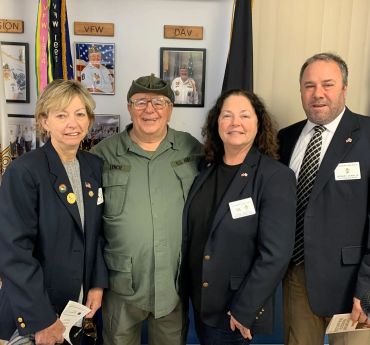 Group of four veterans posing indoors.