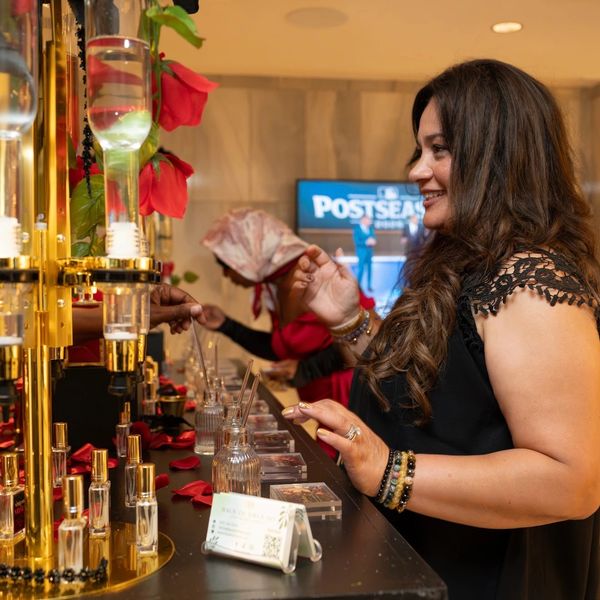 Woman enjoying a scent testing experience at a perfume counter.