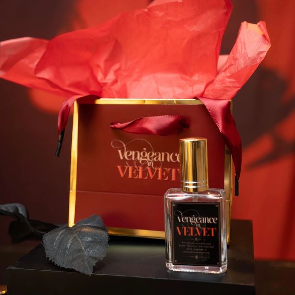 Luxury perfume bottle and gift bag with red and gold accents.