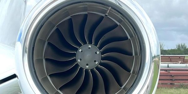 Close-up of a jet engine turbine with blades visible inside.
