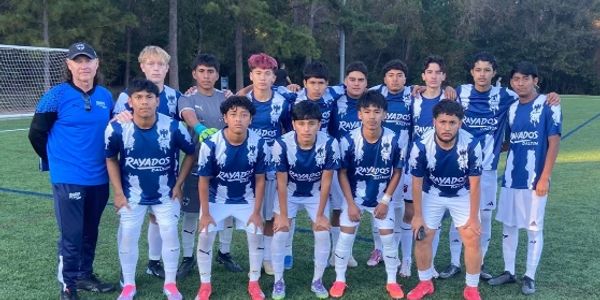 Youth soccer team posing on the field in blue and white uniforms.