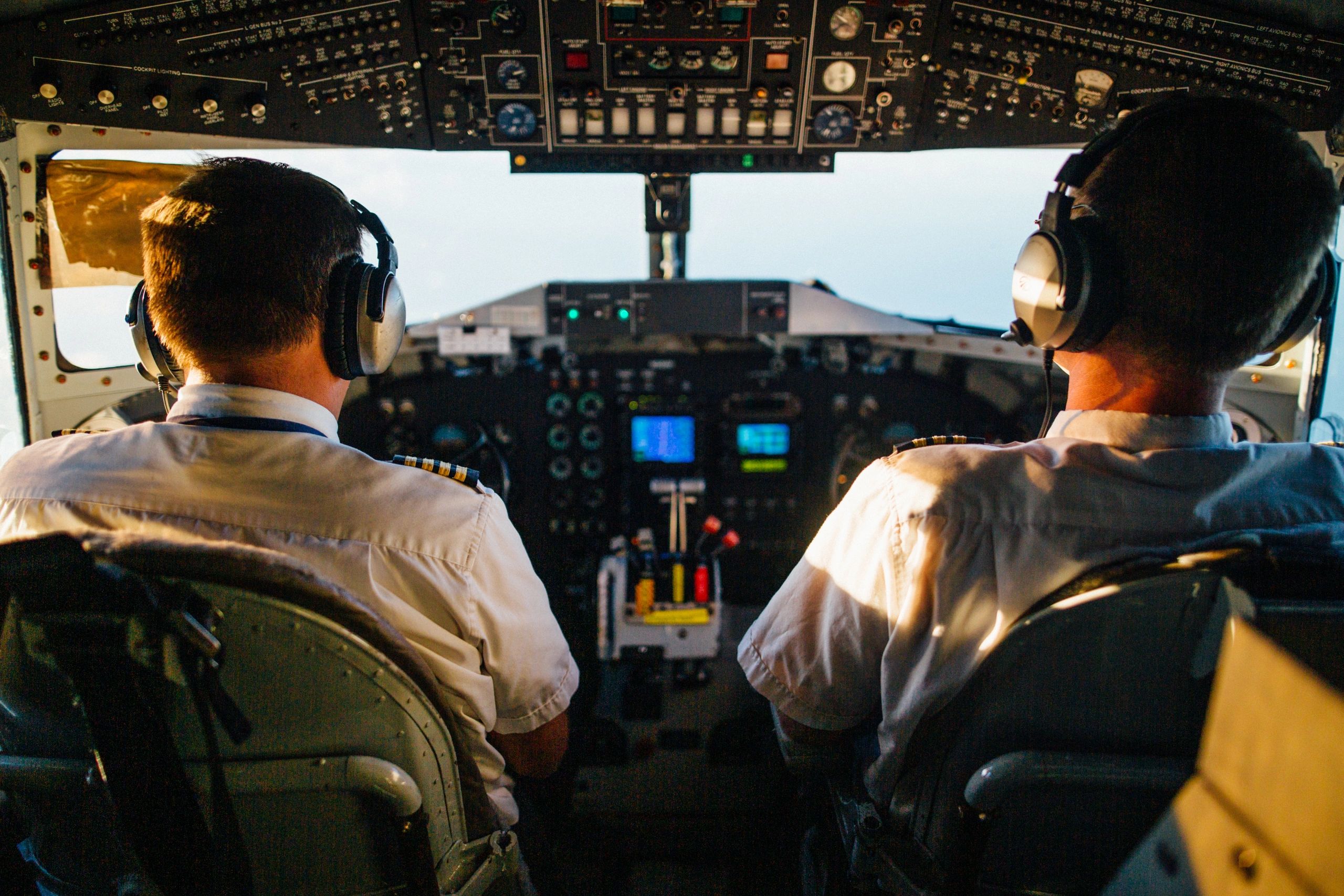 Two pilots sitting in a cockpit of an airplane