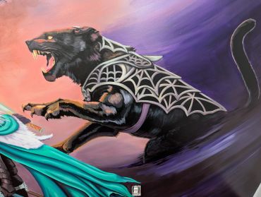 A fierce black panther wearing spiderweb armor lunges forward.