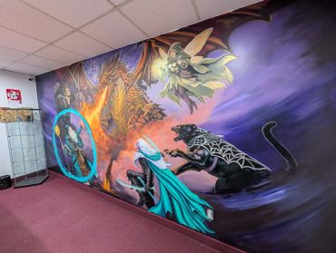 A vibrant fantasy mural featuring a dragon, magical figures, and a panther on a wall.