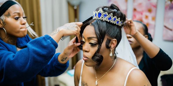 Bride getting her hair styled with a jeweled crown and veil.