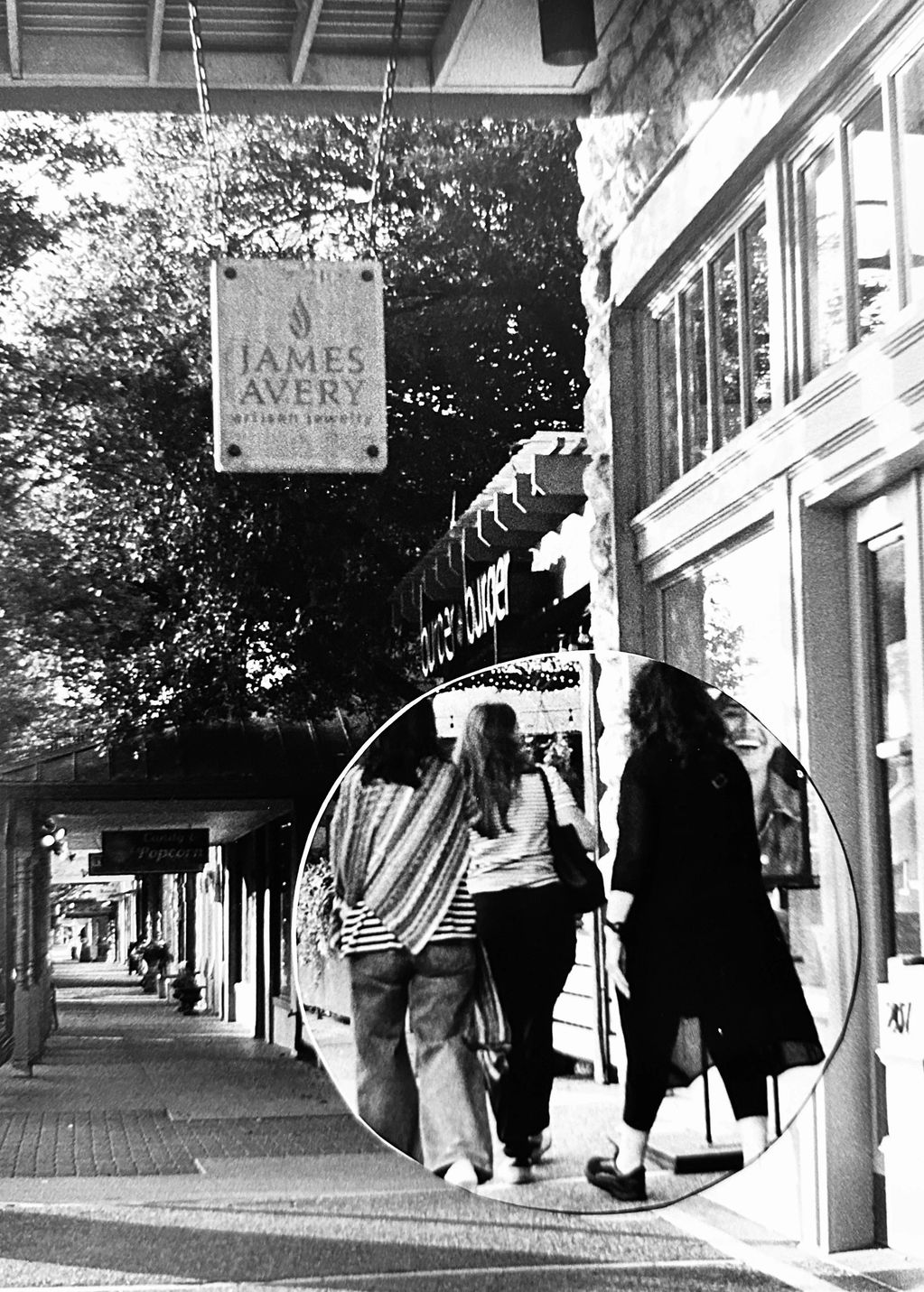 Black and white photo of three women walking on a street.