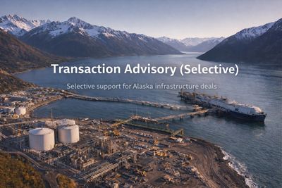 Aerial view of an industrial port in Alaska with mountains in the background.