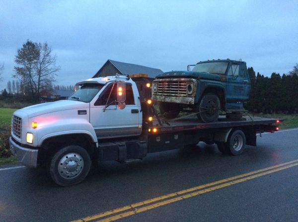 Scrap car loaded onto flat deck for eco-friendly disposal in Burnaby