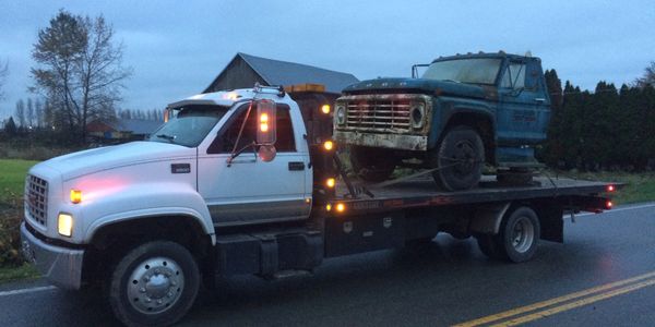 Scrap car loaded onto flat deck for eco-friendly disposal in Burnaby