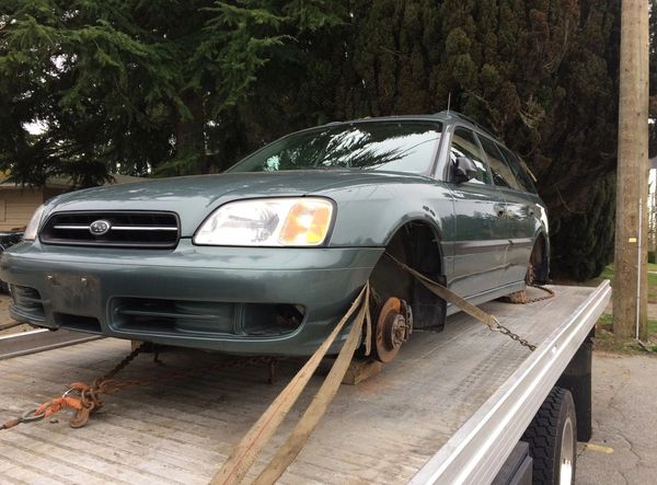 Free car removal service towing a vehicle with missing wheels