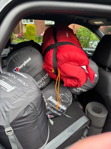 Sleeping bags packed in a car's back seat.