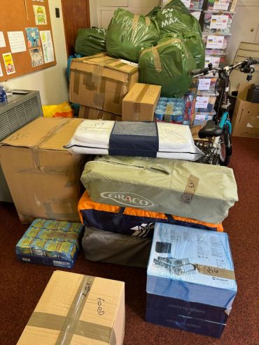 Stack of packed boxes and bags with labels indoors.