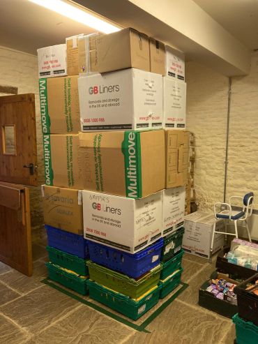 Stacked boxes labeled with various items in a room.