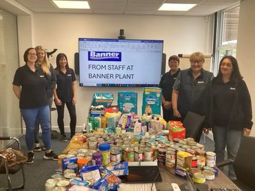 Banner Plant staff with a large collection of donated food items.