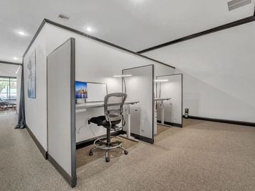 Modern office cubicles with ergonomic chairs and desktop computers.