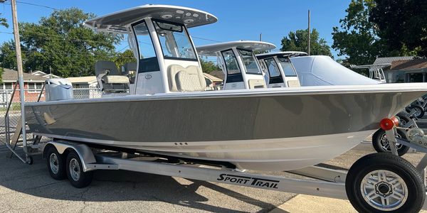 Sleek gray sport fishing boat on trailer under clear sky.