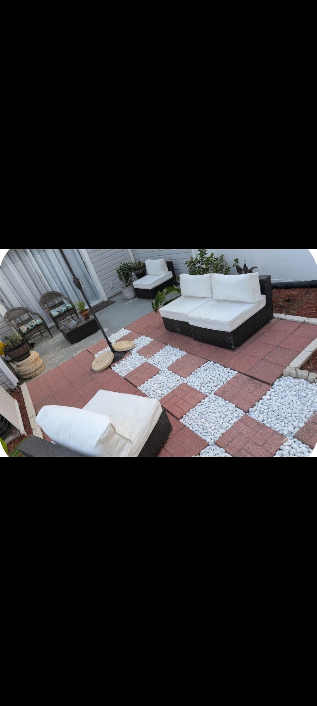 Cozy patio with wicker furniture and patterned stone tiles.