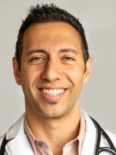 Smiling doctor in white coat with stethoscope.