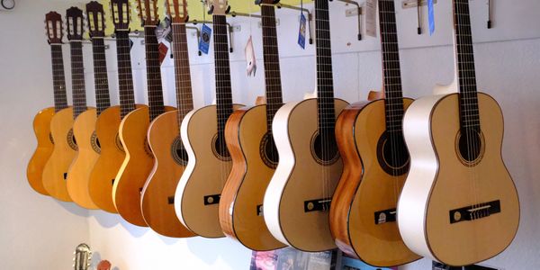 Akustikgitarren, welche zum Verkauf oder zum Mietkauf im Musikgeschäft hängen