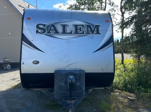 Front view of a Salem travel trailer parked outdoors near trees.