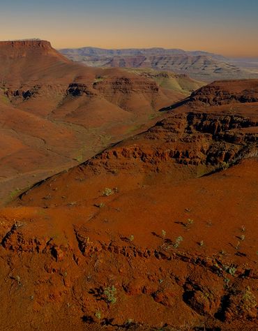 Expansive view of a reddish-brown desert canyon landscape at sunset photo wayne quilliam indigenous 