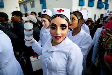 People dressed as nurses with exaggerated masks and white uniforms at a lively event.