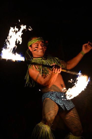 A fire dancer performing a traditional Polynesian fire dance at night.