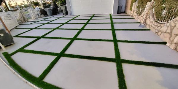 Concrete driveway with grass strips arranged in a grid pattern.