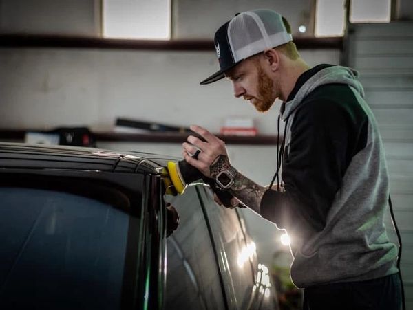 professional paint correction being performed before ceramic coating process on black suv 