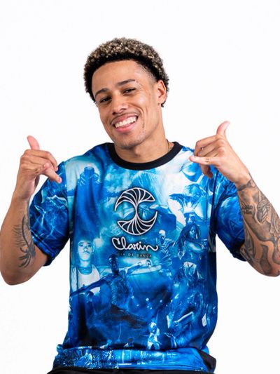 Smiling man in a vibrant blue graphic t-shirt making hand signs.