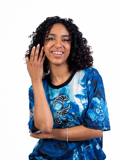 Mulher sorrindo com camisa azul estampada.