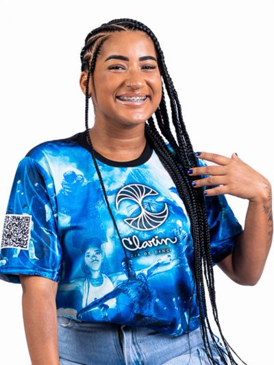 Smiling woman with long braids wearing a vibrant blue graphic t-shirt and braces.