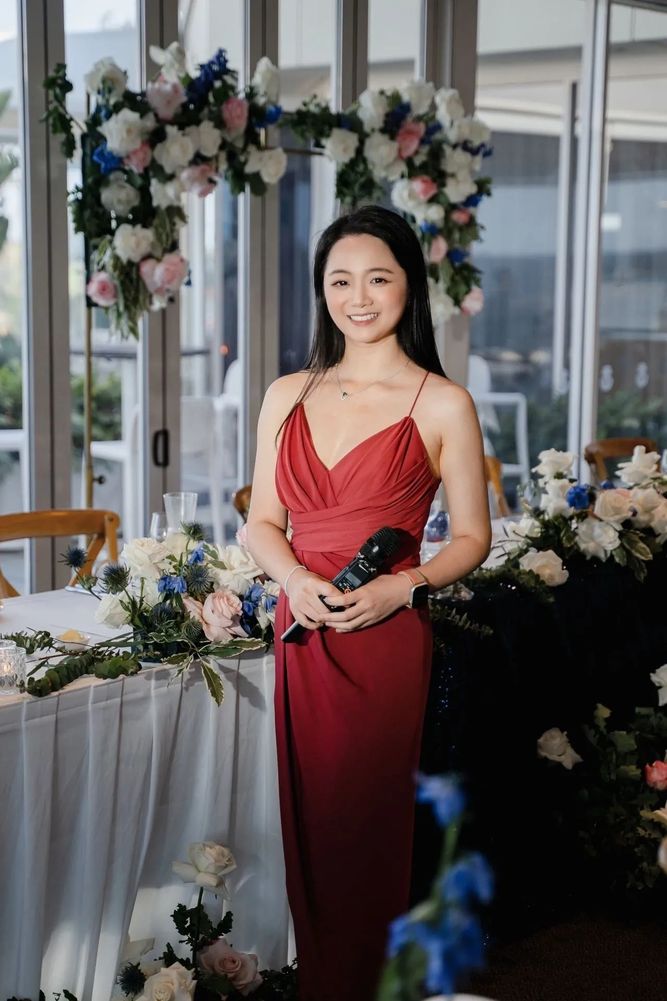 Black pencils in a gray holder next to a stack of white magazines with a camera in the background.