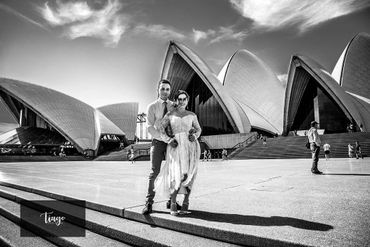 couple possing at the front of opera house