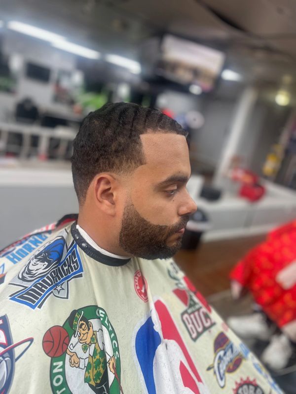 Man with fresh haircut and beard trim in a barber shop.