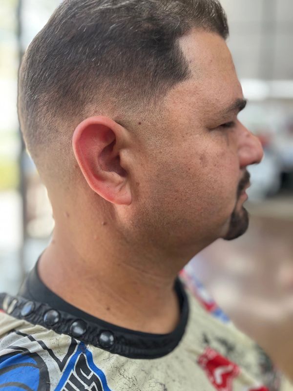 Close-up of a man's fresh haircut and trimmed beard in profile.