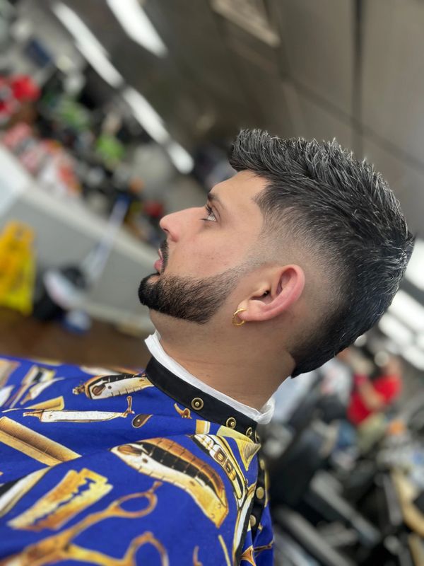 Man with a fresh haircut and beard trim at a barbershop.