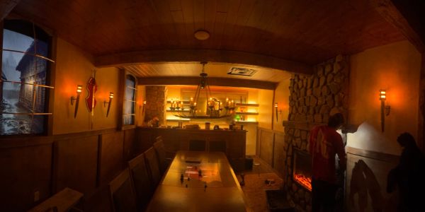 Cozy rustic room with fireplace and bar.