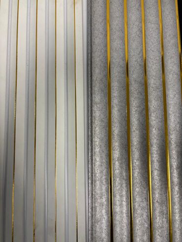 Close-up of two textured surfaces with gold vertical stripes, one white and one gray.
