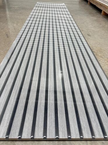 A long sheet of corrugated metal with alternating black and gray stripes.