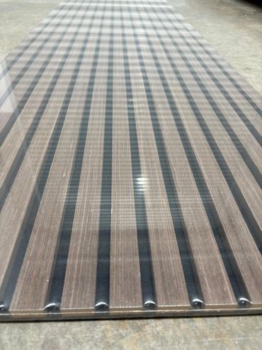Long wooden plank with black vertical stripes and metal rivets on the edges.