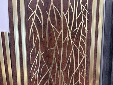 Elegant wall art with gold branch patterns on a rich brown background.