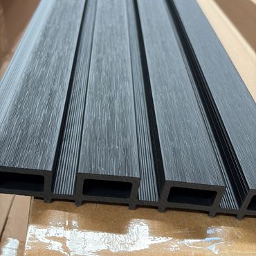 Close-up of textured black plastic extrusion profiles with hollow rectangular sections.