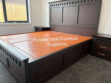 Dark wooden Punjabi style bed with storage drawers and matching nightstands.