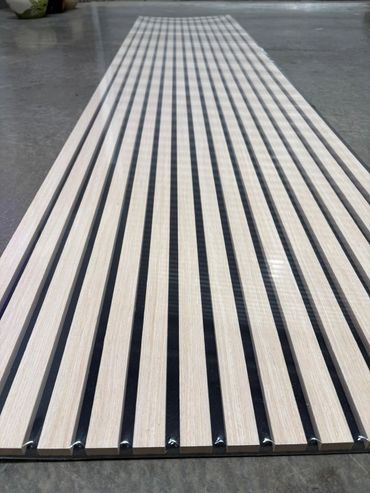 Wooden slats evenly spaced on a black base, arranged on a concrete floor.