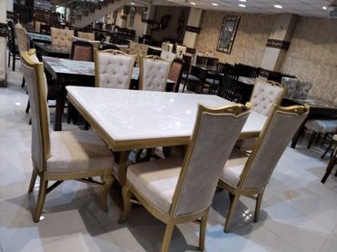 Elegant dining table set with cushioned chairs in a showroom.