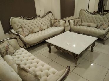 Elegant vintage tufted sofas with a matching white marble coffee table in a cozy living room.