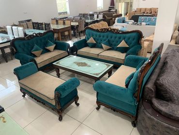 Elegant teal and beige sofa set with wooden accents in a showroom.