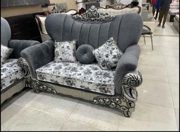 Elegant gray and floral upholstered sofa with ornate carved wooden frame.