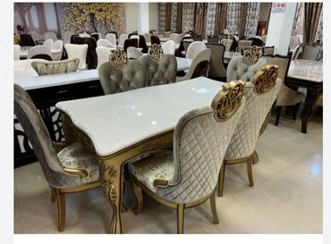 Elegant dining set with ornate chairs and a marble table in a showroom.